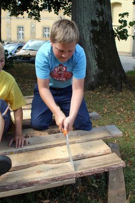 Eifrig werkeln die Kinder, damit die Holzhäuser rechtzeitig fertig werden.