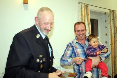 Branderzieher Freiherr Thilo von Hanstein von der Freiwilligen Feuerwehr Ensdorf (li.) überreicht Rauchwarnmelder.