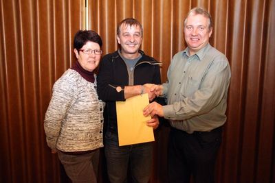 Die Kassiererin des Gemeindefests Monika Seebauer (li.) überreichte mit Bürgermeister Markus Dollacker (re.) im Namen der Gemeinde dem bisherigen Organisationsleiter Werner Scharl (Mi.) „ein kleines Dankeschön als Zeichen der Anerkennung und Wertsch
