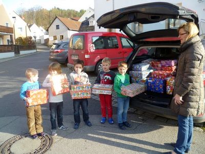 Maria Leikam und Kinder des Kindergarten St. Jakob Ensdorf verladen die Hilfspakete.