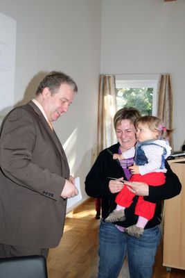 Bürgermeister Markus Dollacker bei der Übergabe der Geschenke an die neuen Gemeindebürger und deren Eltern.