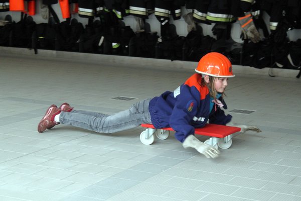 Rollbrett- Staffelrennen in Jugendfeuerwehrbekleidung.