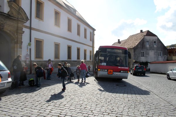 Schulbushaltestelle beim Torbogen vor dem Kloster.