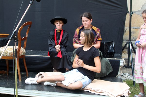Don Bosco (Jonas Huber) und seine Mutter Margherita (Annika Piesche) nehmen einen Waisenjungen (Sarah Marschall) im Regen auf.