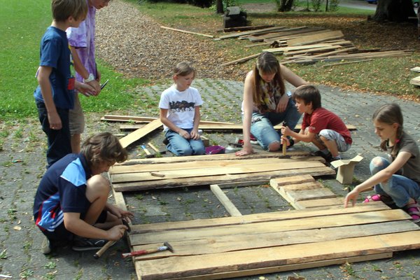 Eifrig werkeln die Kinder, damit die Holzhäuser rechtzeitig fertig werden.