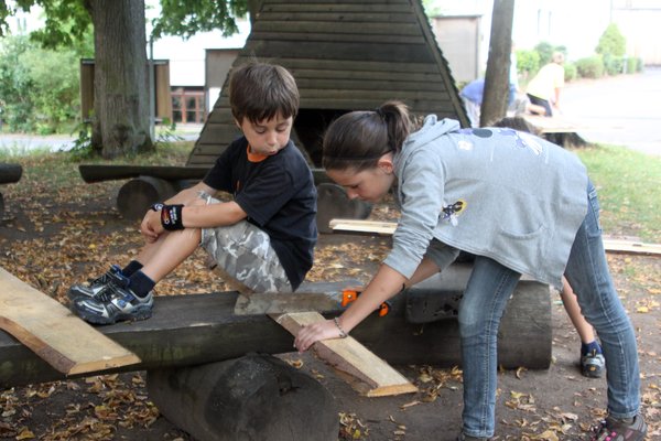Eifrig werkeln die Kinder, damit die Holzhäuser rechtzeitig fertig werden.