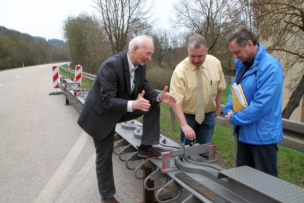 Abteilungsleiter Brückenbau beim Staatlichen Bauamt Amberg-Sulzbach, Winfried Schaller, erläutert Ensdorfs Bürgermeister Markus Dollacker die lärmdämmende Wirkung der neuartigen wellenförmigen Dehnfugen. Rechts Projektleiter Kurt Scharf.